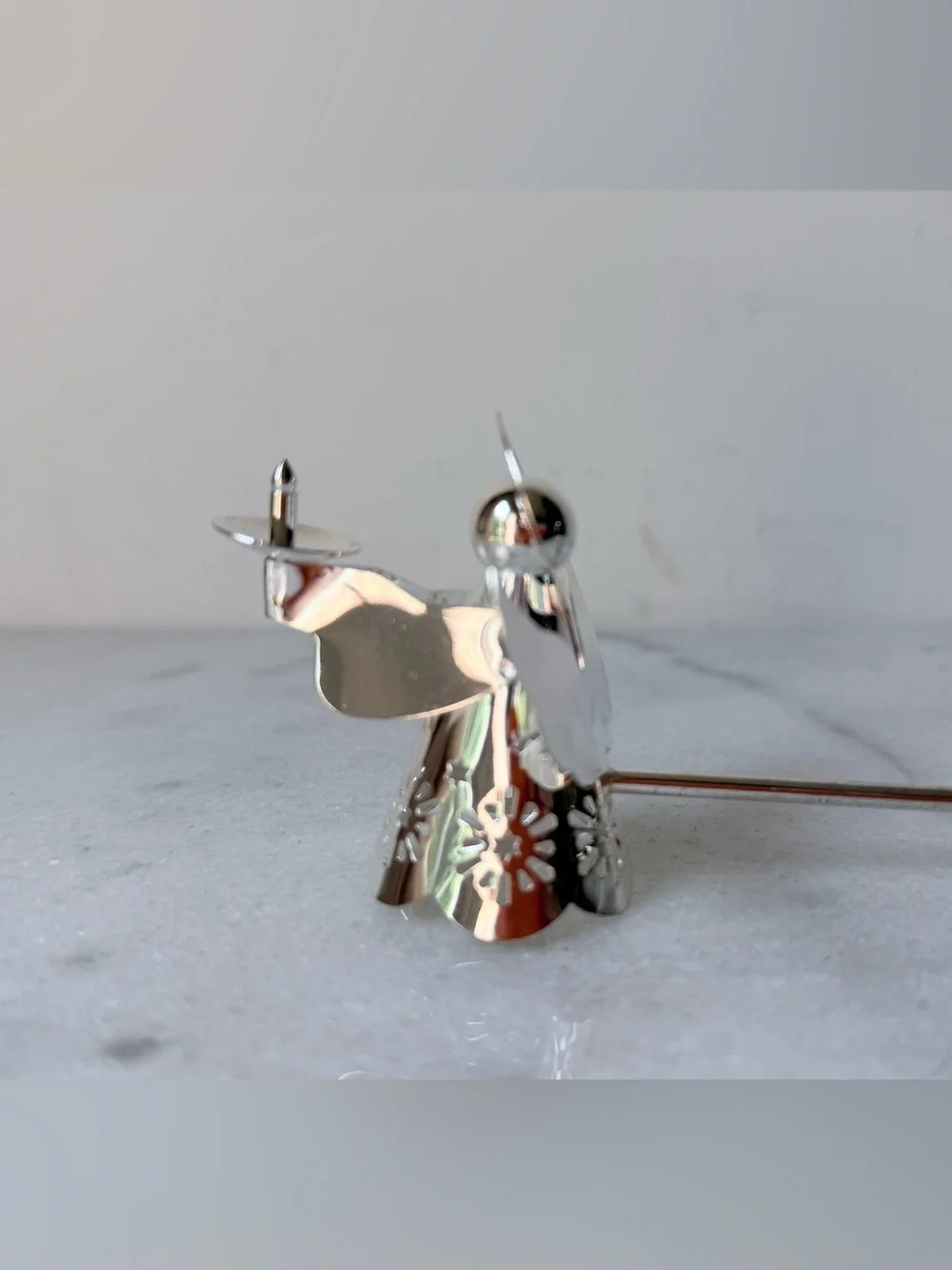 silver-tone angel candle snuffer features intricate, cutout wing and robe